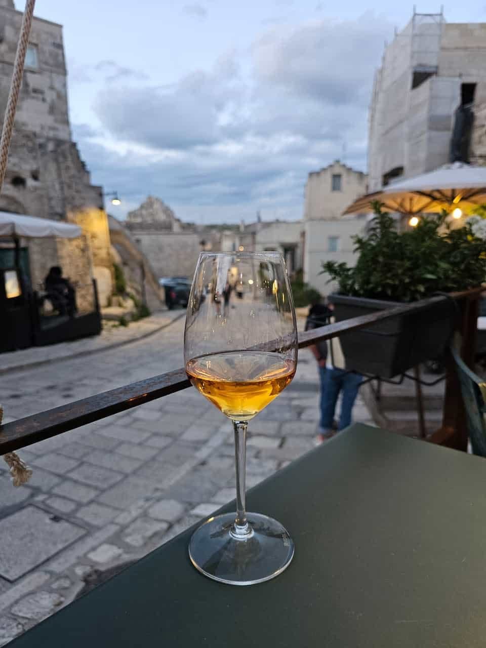 Calice di vino sulla terrazza con vista sui Sassi