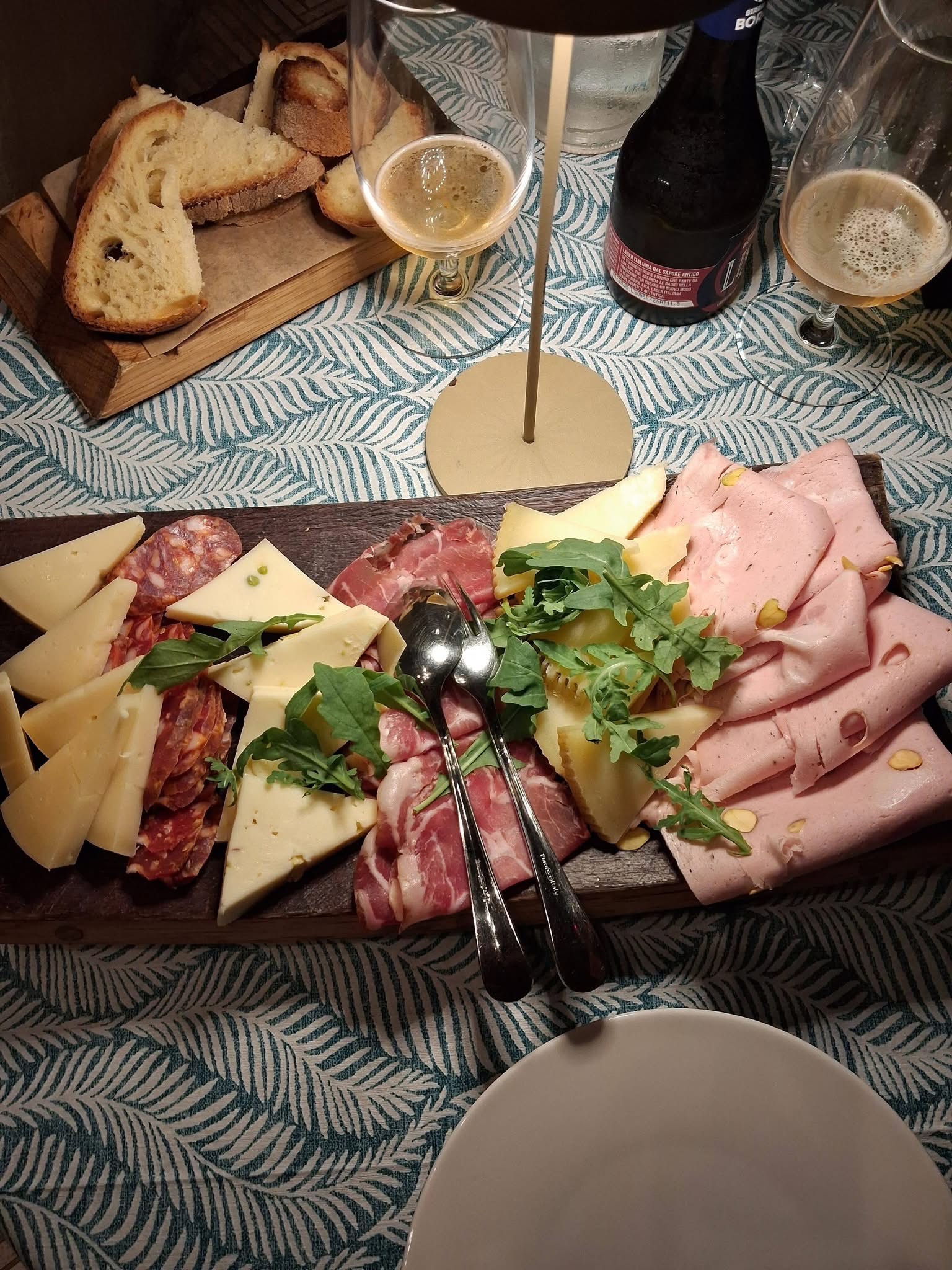 Tagliere con salumi, formaggi, pane e calici